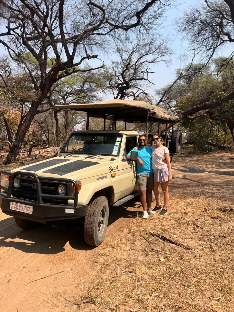 Visitors beside an open safari vehicle